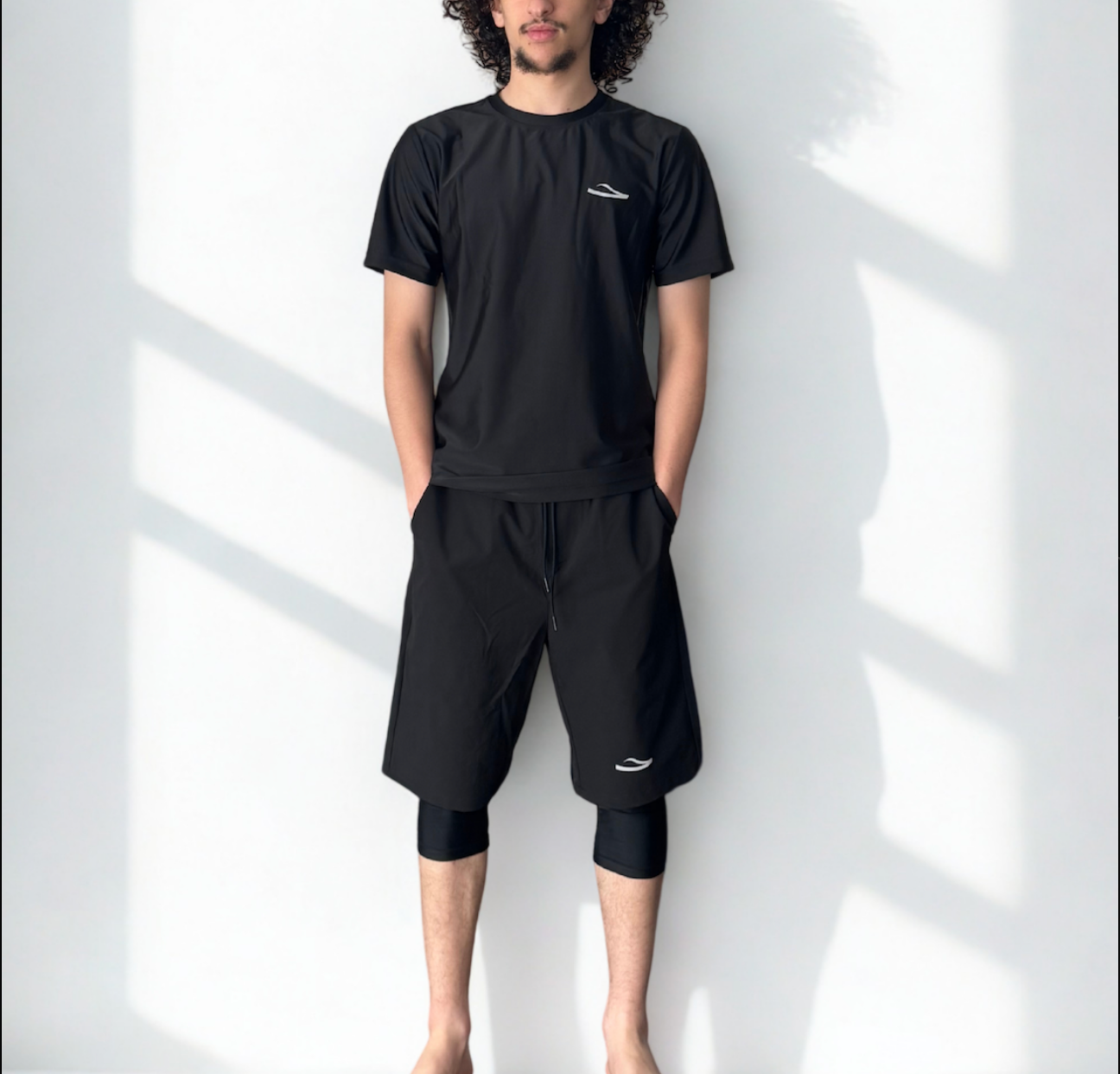 Homme portant un short de bain musulman noir pudique avec legging intégré et t-shirt assorti – vue de face